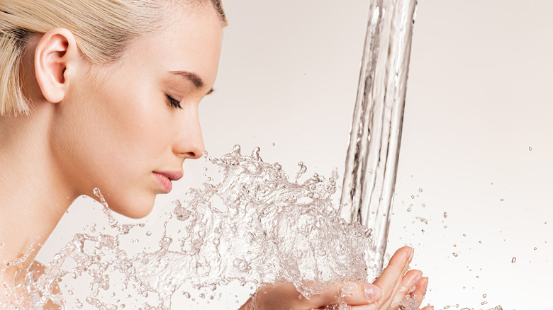 Woman splashing water on face