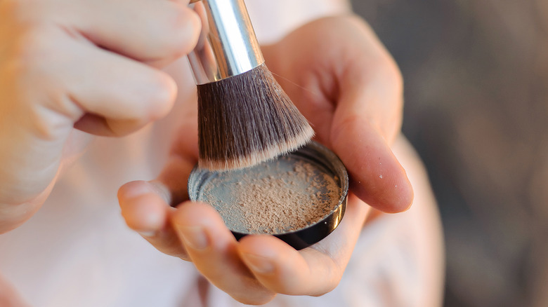 woman using kabuki brush