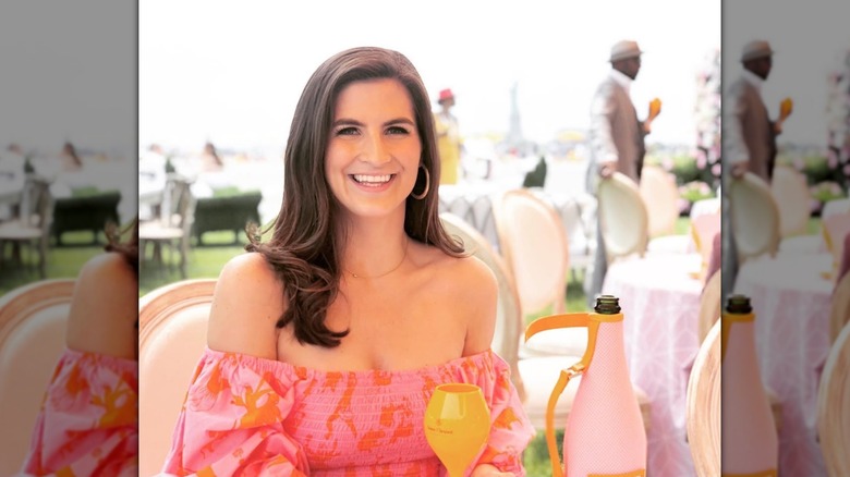 Kaitlan Collins with side parted hair and curled ends