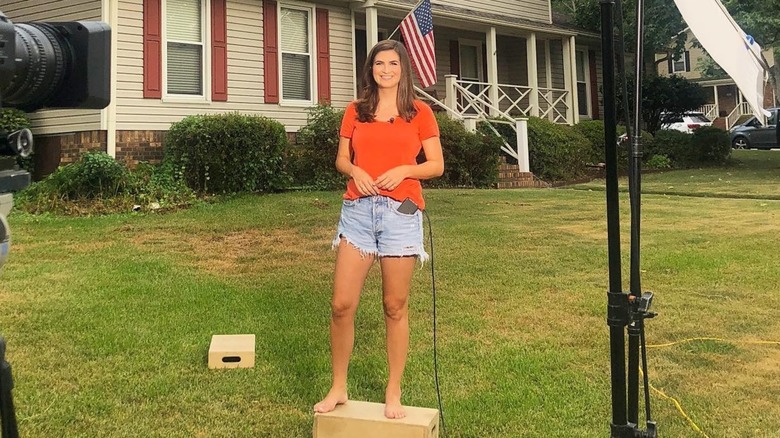 Kaitlan Collins stands in front her sister's home and smiles (August 2019)