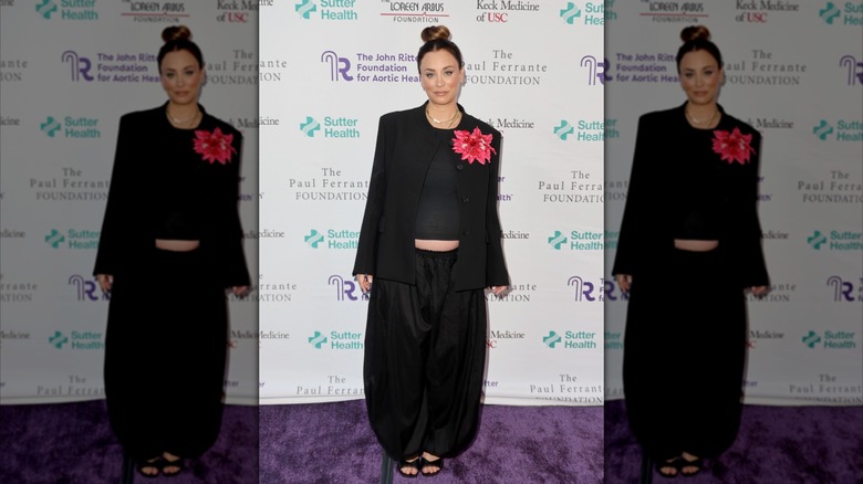 Kaley Cuoco smiles in a black suit