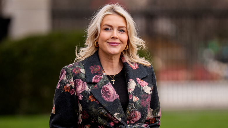 Karoline Leavitt walking towards the West Wing wearing an unflattering coat that makes her look older than her age