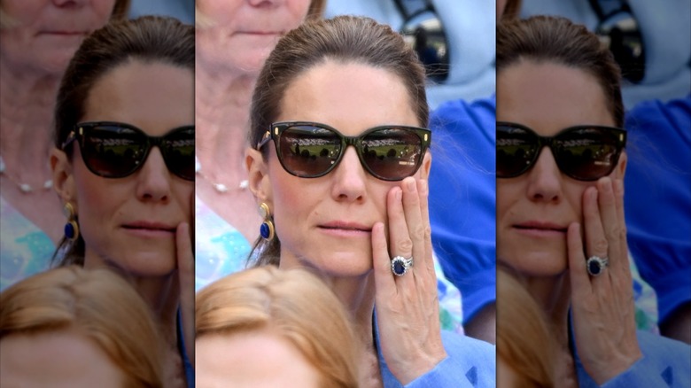 Kate Middleton wearing sunglasses with her hand on her cheek at Wimbledon 2026.