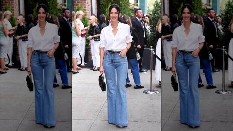 A woman in a white button down and jeans.