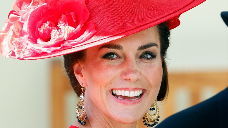 Kate Middleton smiling in red hat