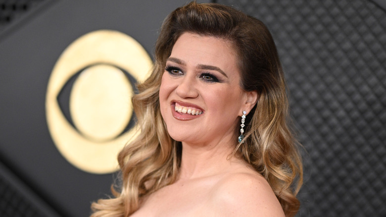 Kelly Clarkson posing for a photo in a white dress