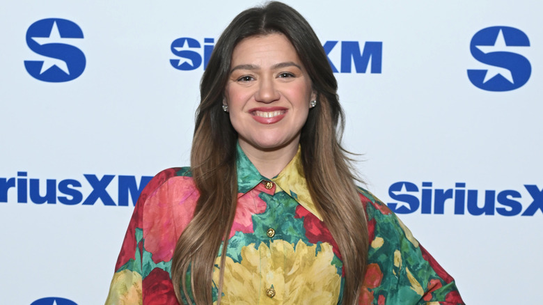 Kelly Clarkson wearing a red, yellow and green floral dress in 2026
