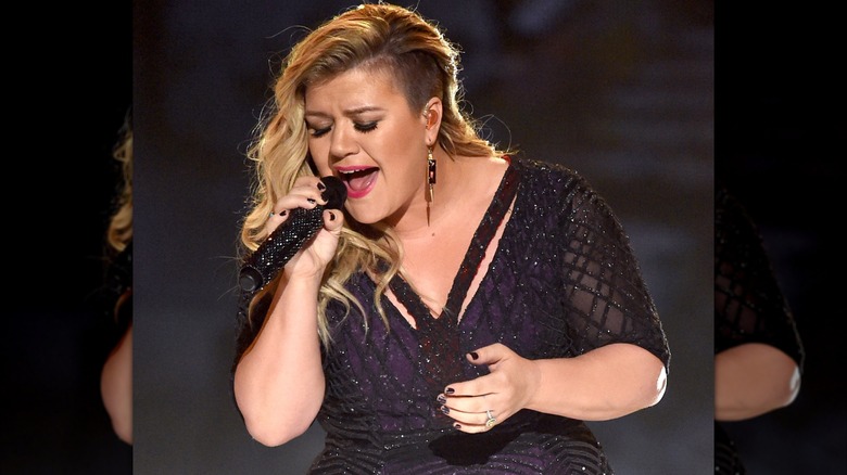 Kelly Clarkson with a shaved undercut performing on stage in 2015