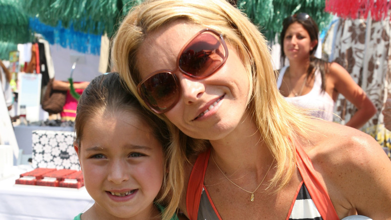 Young Lola Consuelos posing next to her mom Kelly Ripa.
