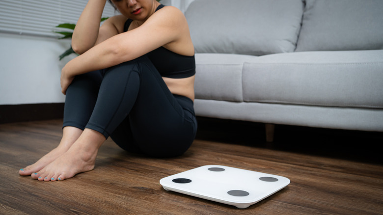 woman sitting next to scale