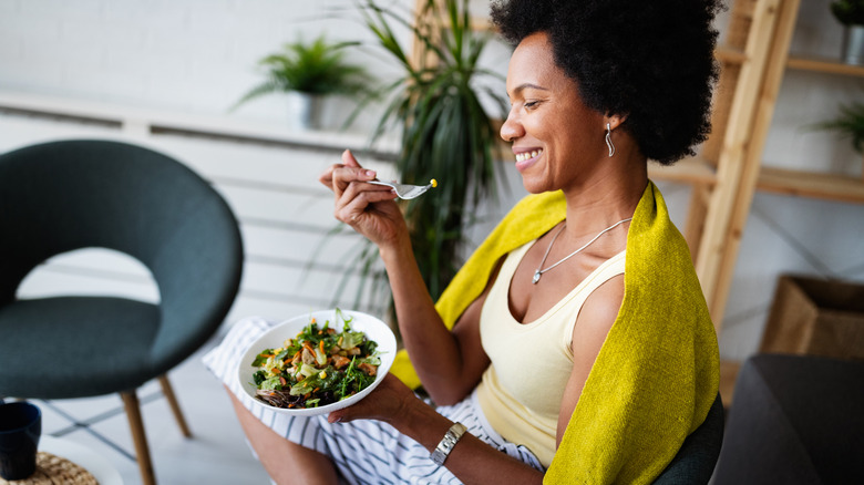 smiling woman eating salad