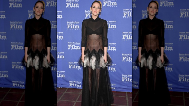Kristen Stewart posing in a see-through black dress