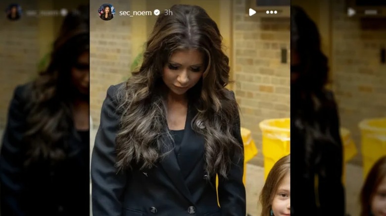 Kristi Noem looking downward showing her poor application of hair extensions