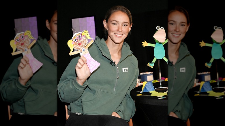 Kylie Kelce holding up a paper doll of a woman's body