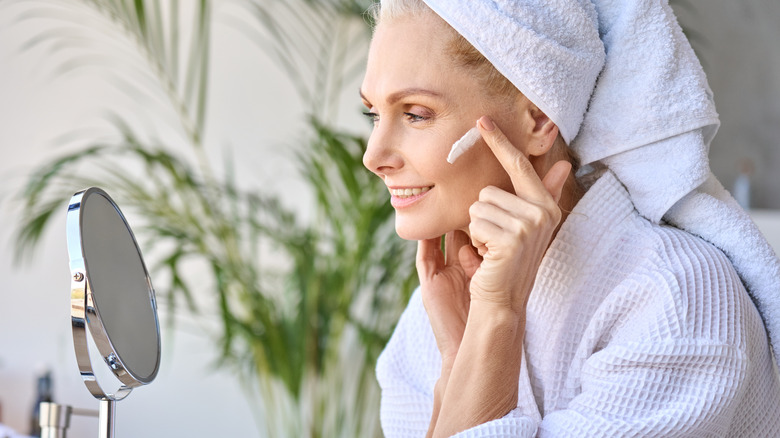 middle-aged woman applying face cream