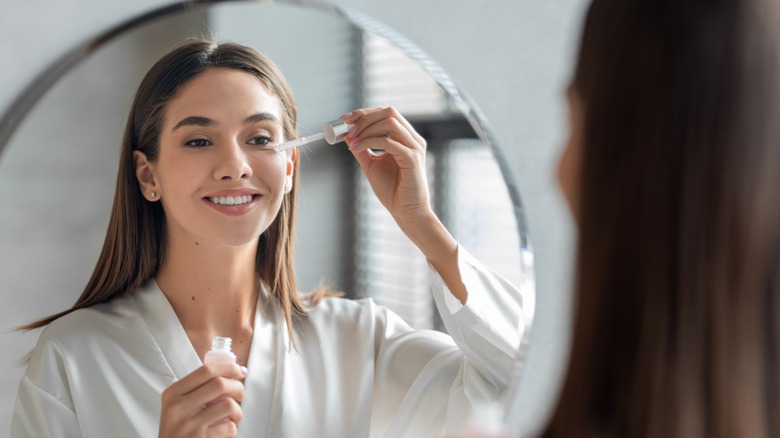 woman putting serum her face