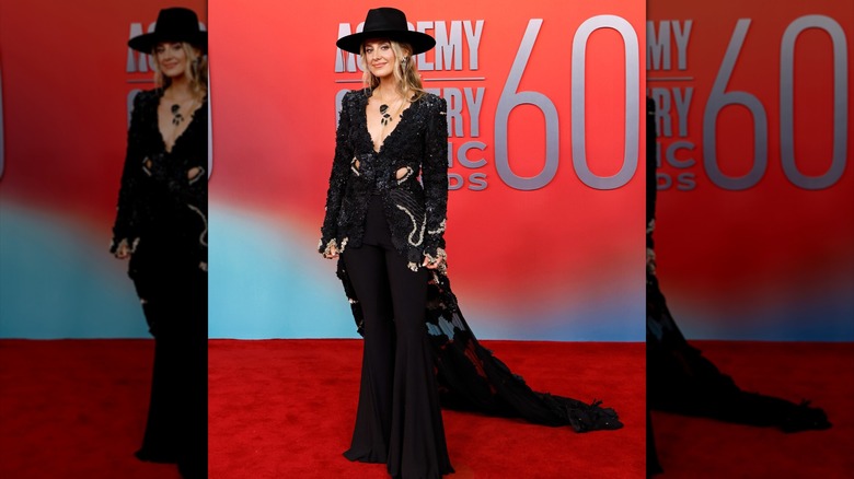 Lainey Wilson wearing a black outfit on the red carpet