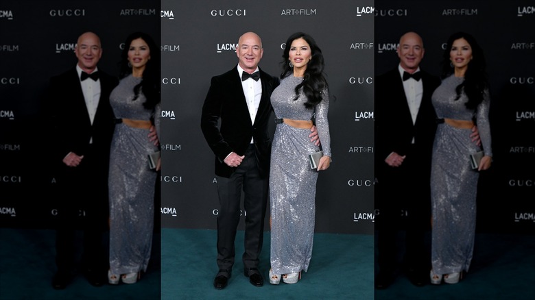Lauren Sánchez Bezos poses next to Jeff Bezos (left) wearing a silver gown.