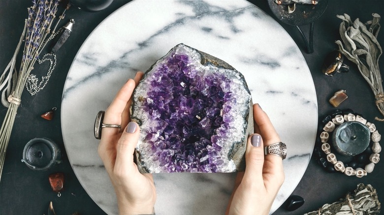 Woman's hands placing geode on altar