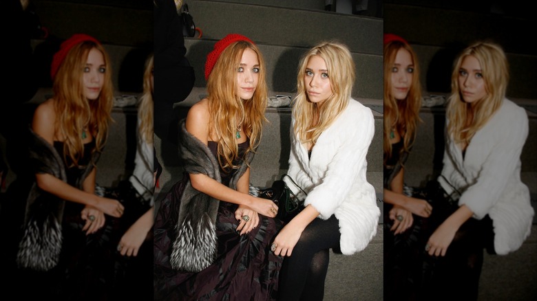Mary Kate Olsen and Ashley Olsen photographed at a fashion show wearing indie sleaze styles.