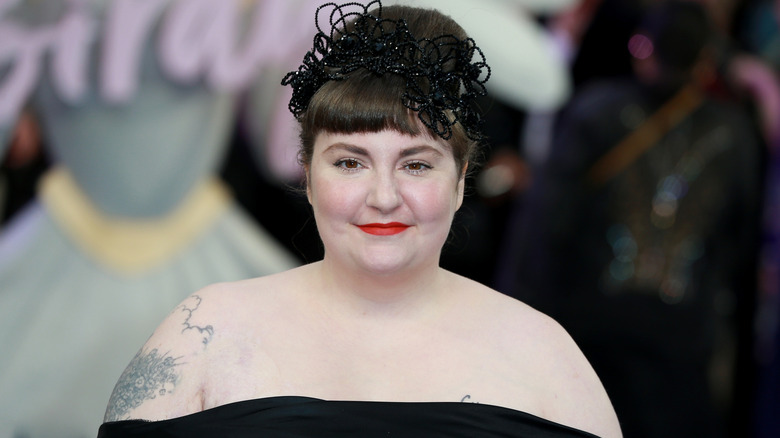 Lena Dunham wearing a black dress and red lipstick