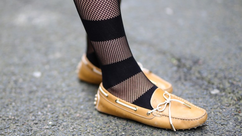 A pair of beige boat shoes with mesh striped socks