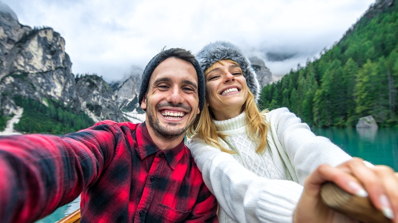 Happy couple rowing boat in Scandinavia