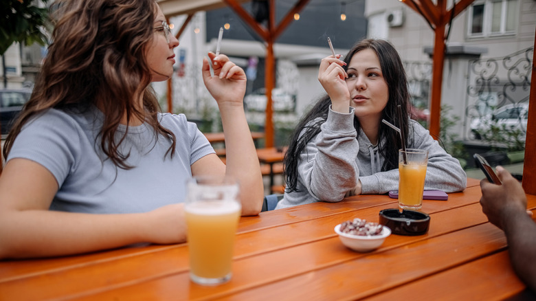 women smoking and drinking at a table