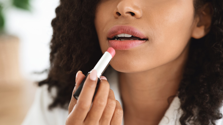 Woman applying bloss lipgloss