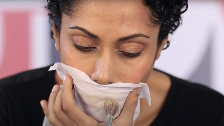 woman applying powder to lips