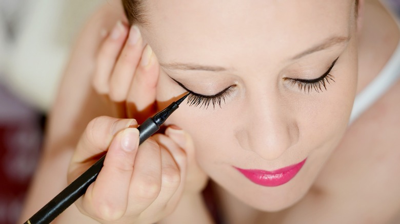 Woman applying eyeliner