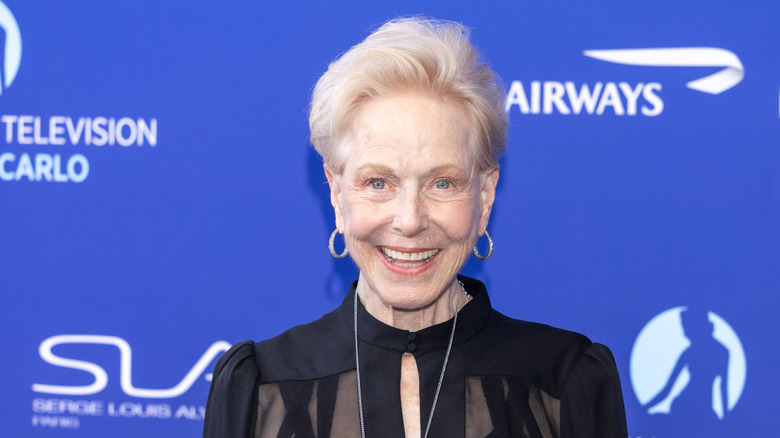 Karen Grassle smiles at a red carpet wearing a black dress