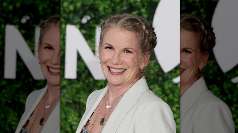 Melissa Gilbert smiles wearing her gray hair in a braided crown