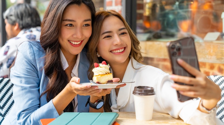 Woman taking selfie with friend