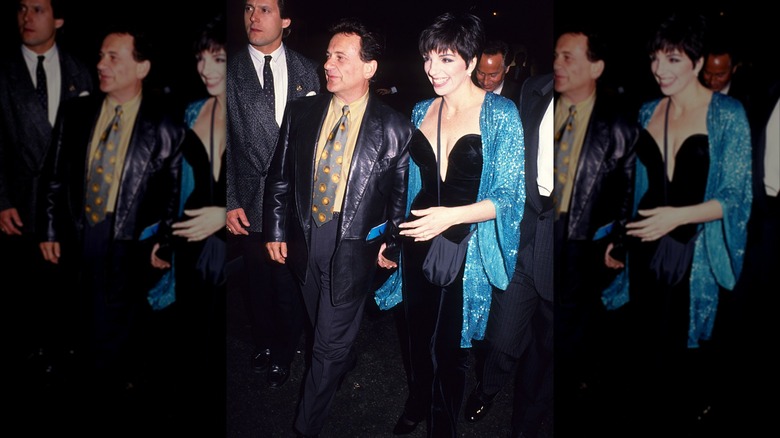 Liz Minnelli pictured with Joe Pesci wearing a blue sparkly top over a black dress.