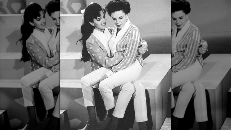 Black and white photo of Liza Minnelli next to her mother Judy Garland on a set.