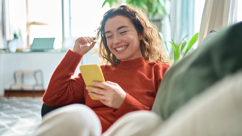 woman smiling at smartphone