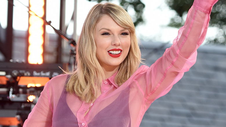 Taylor Swift waving pink blouse