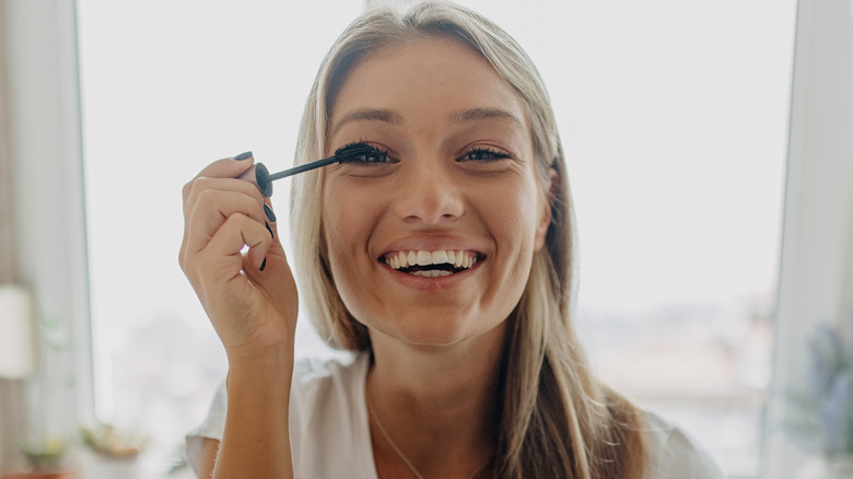 woman applying coat of mascara