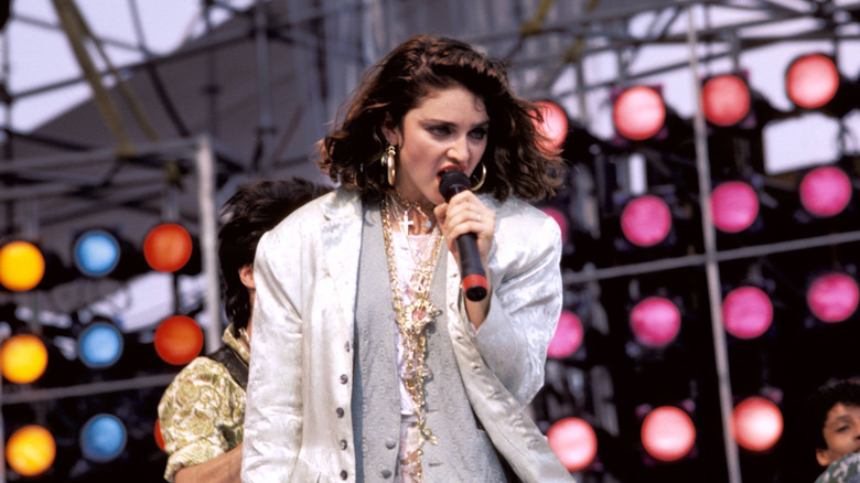 Madonna performs on stage with dark brown hair