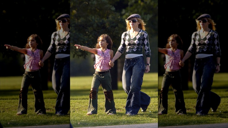 Madonna and Lourdes Leon hold hands wearing flared jeans at a park