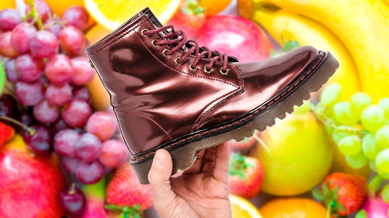 Leather shoe foregrounding a bunch of fruits