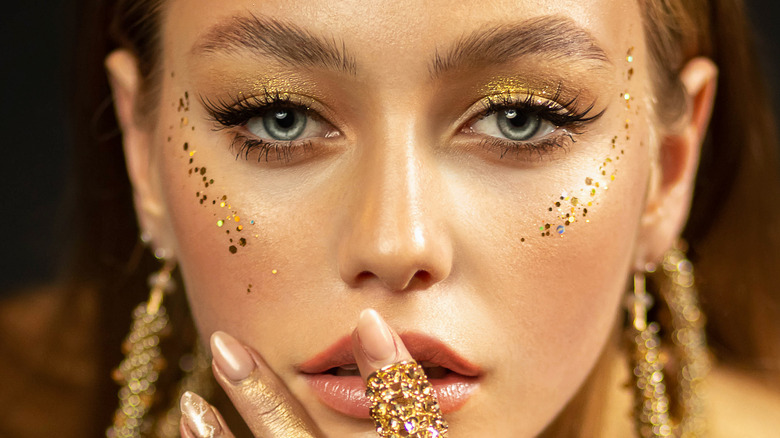 A woman wearing gold eye makeup 
