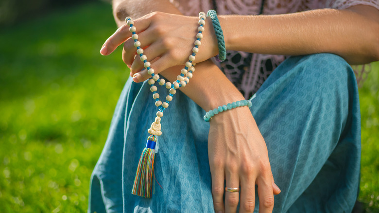 Person holding mala beads