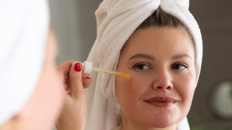 Woman applying serum with pipette