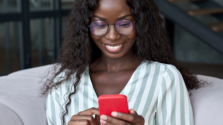 smiling woman using smartphone