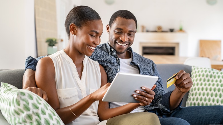 couple smiling while reviewing finances