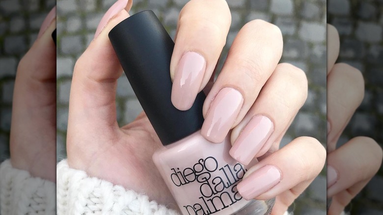 long flesh-toned nails holding polish
