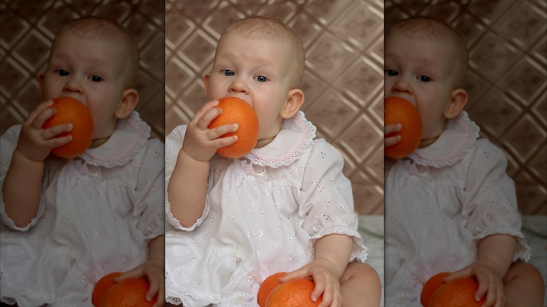 Baby eating an orange