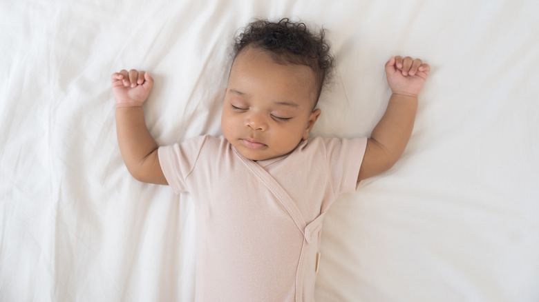 Baby sleeping with her arms up
